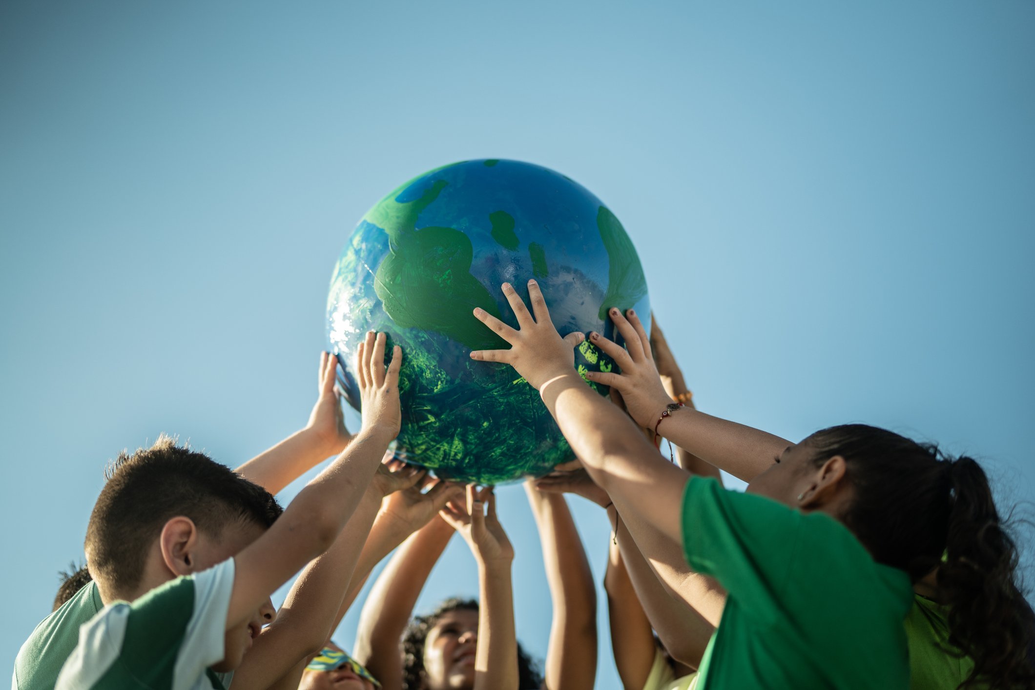children holding up a miniature globe