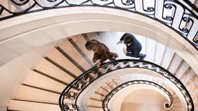 Two people climbing up a spiral staircase.